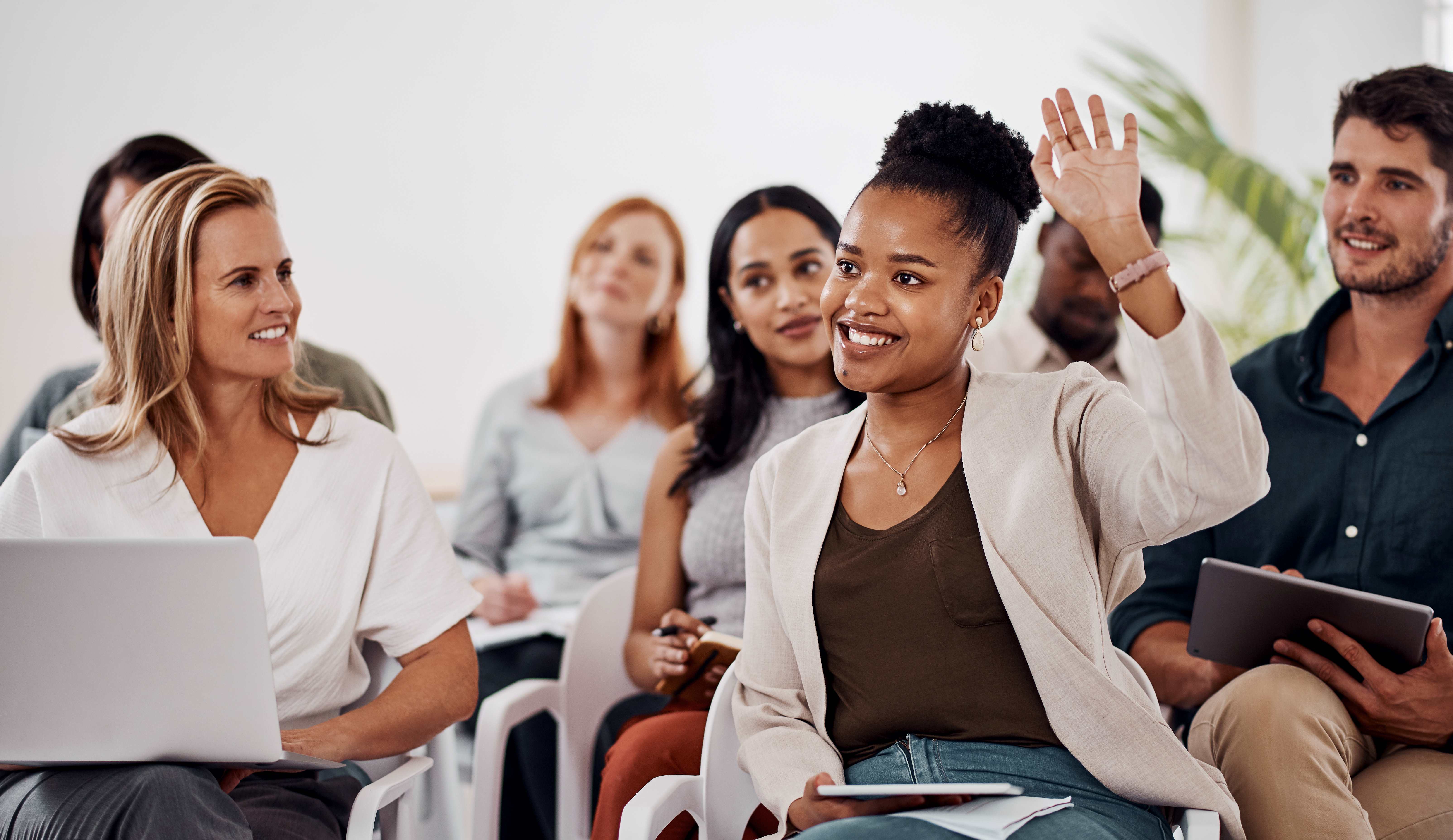 woman raising hand in corporate training course