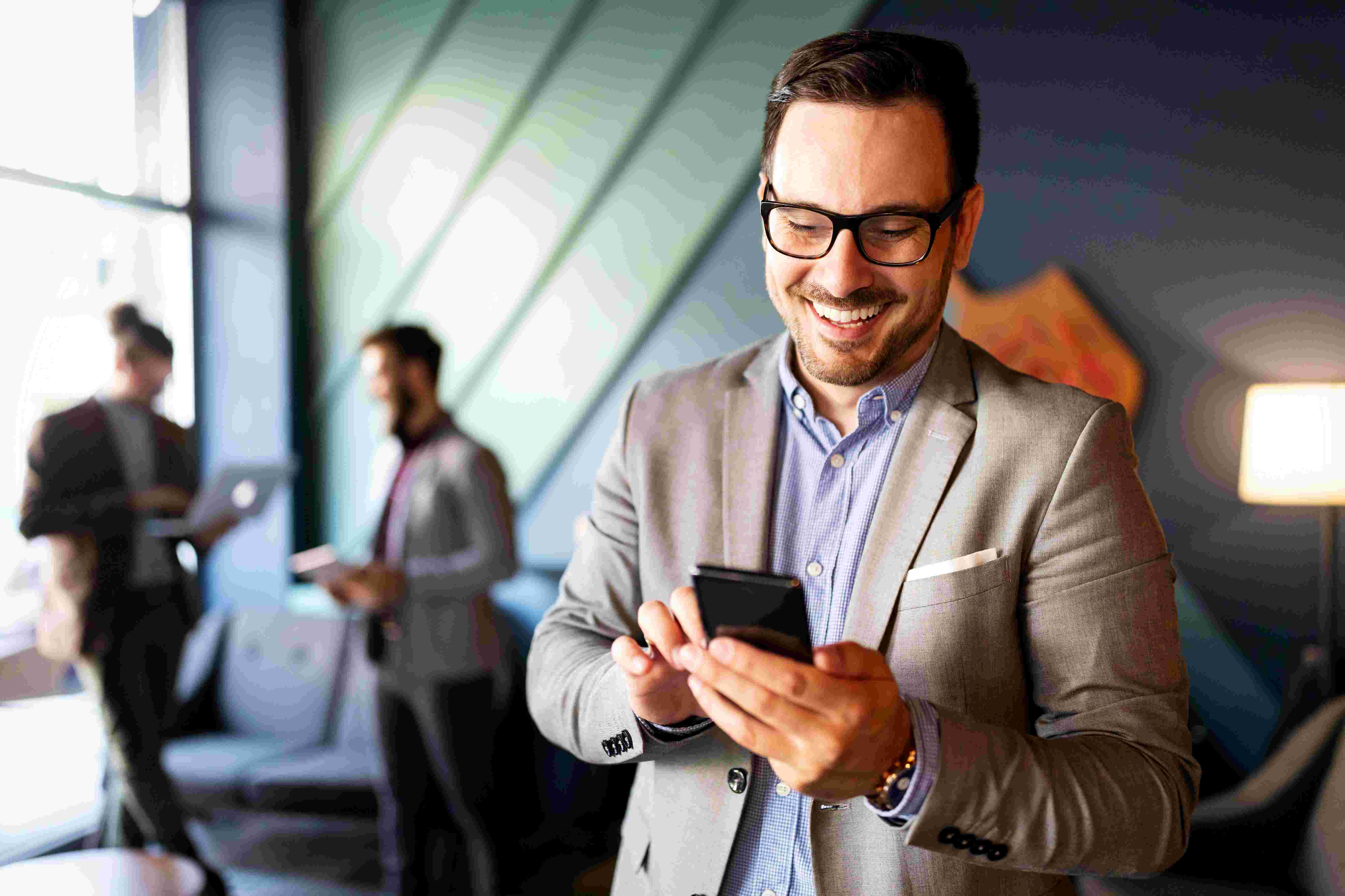 man on mobile 5G phone in office